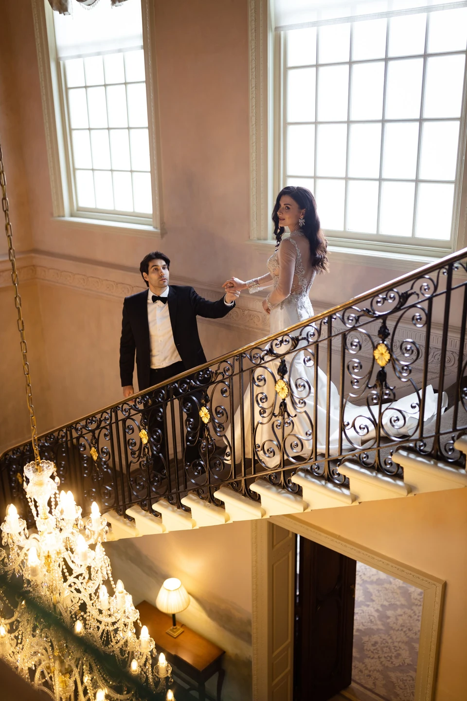 Angelina and Dom holding hands on the staircase at Hedsor House — Buckinghamshire