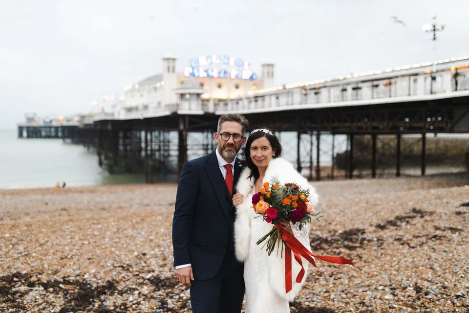Jodie and Gregg on the beach with the Palace Pier behind them — Brighton