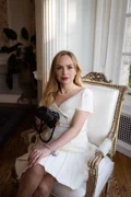 Kate Lucas holding her camera beside a window