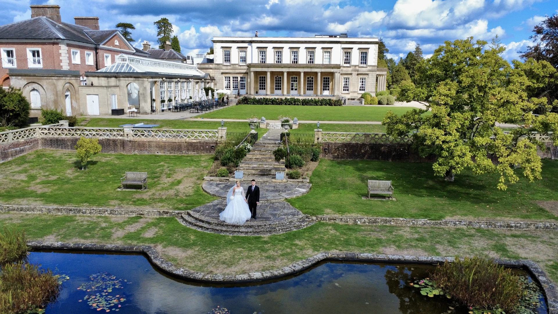 Drone wedding portrait beside the pond at Buxted Park Hotel — Sussex